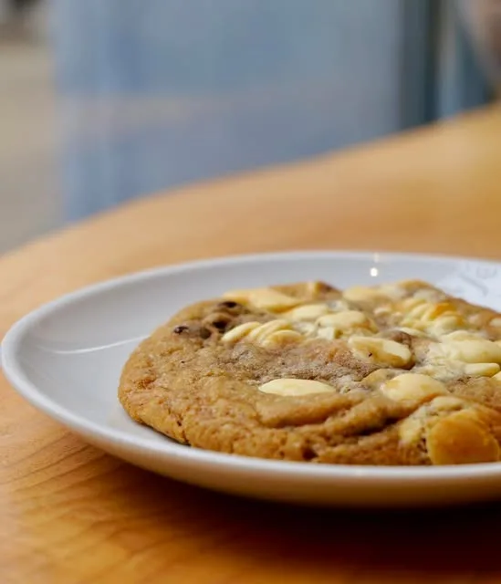 Cookie géant aux pépites de chocolat blanc sur une assiette