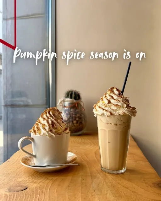 Deux boissons pumpkin spice garnies de chantilly, sur une table en bois